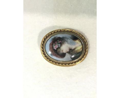 A Victorian yellow metal oval mourning brooch with double bead and rope pattern border, with later porcelain Victorian style 