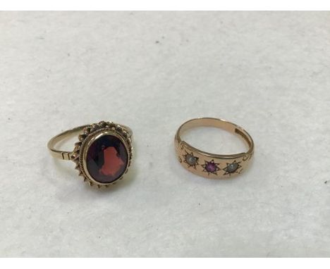 A 15ct gold ruby and pearl ring and a 9ct gold oval garnet set ring with rope pattern border (stone: approx 2ct) (5.96g) (2)