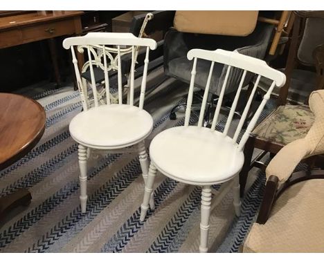 A pair of white painted spindle back kitchen chairs with circular shaped seats, on ring turned tapered splay supports (h.82cm