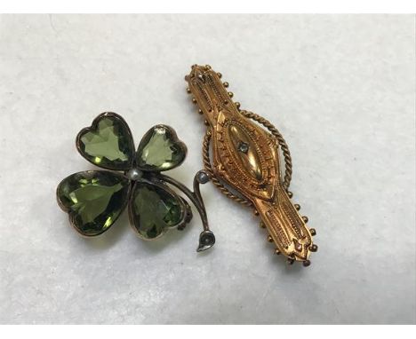 A yellow metal mounted four leaf green stone set shamrock with seed pearls (one pearl missing) (d.2.5cm) (6.19g) and a 15ct g