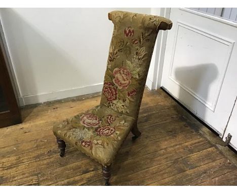 A Victorian walnut framed prie dieu chair with tapestry rose decorated upholstered panel back and seat, on tapered supports w