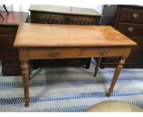 A satinwood birch Edwardian side table, the rectangular top with moulded edge above two frieze drawers, on ring turned tapere