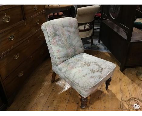 A Victorian walnut framed nursing chair with upholstered panel back and seat, in tapestry machine made fabric, on ring turned