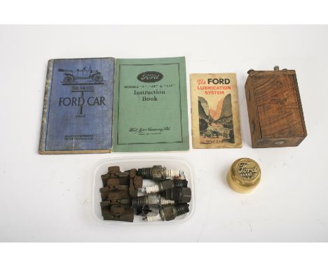 Assorted Ford spares and ephemera,comprising a wooden cased trembler coil, five Model T wheel rim clamps, a brass hub cap, fo