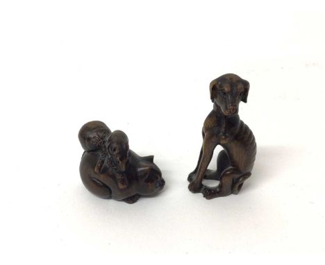 Two wooden Japanese netsuke of animals - one a dog and the other a cat with a rat seated on him