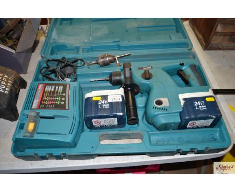 A Makita cased hammer drill with spare battery and a battery charger