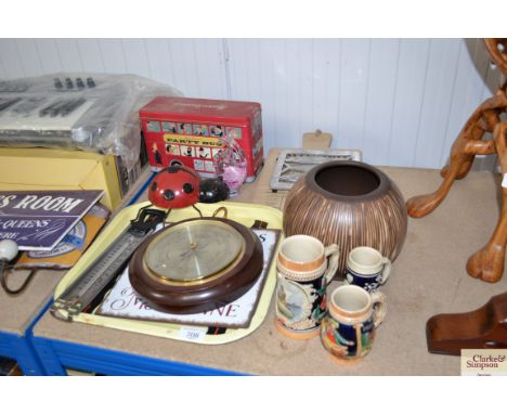 A biscuit tin in the form of a bus, a kitchen chopping board, a barometer, a thermometer, and a German tankard etc.