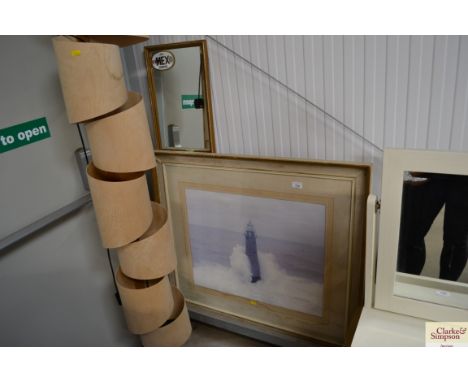 A large print depicting a lighthouse together with an oblong wall mirror