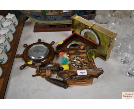 A West German cuckoo clock together with an oak cased barometer from Stowmarket BP Scout Guild and one other mantel clock wit