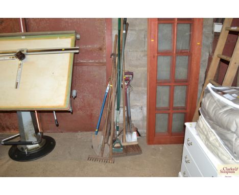 A quantity of long handled garden tools and brushes