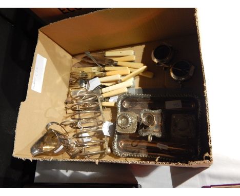 A quantity of silverplate, to include: an inkstand, toast rack, helmet shaped cream jug, pair of salts and fish knives and fo