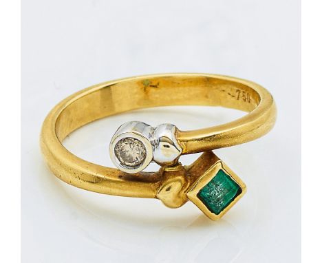 Gelbgold, gest. 750. Diagonal verlaufende Ringschiene, besetzt mit einem Brillanten von ca. 0,10 ct. und einem Smaragdcarrée 