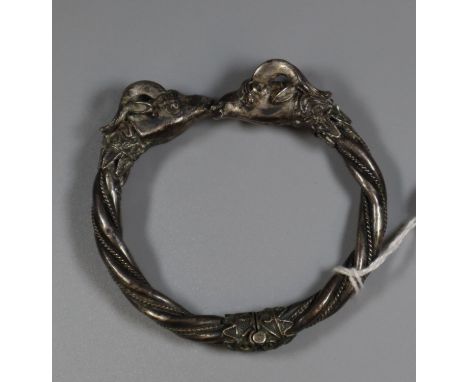 A white metal double goat head bangle.(B.P. 21% + VAT) 