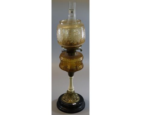 Early 20th Century double oil burner having orange shade, coloured reservoir on a ceramic brass and ebonised stand. (B.P. 21%