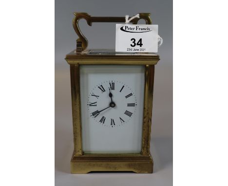 Early 20th Century brass carriage clock, unmarked with white face and black Roman numerals, having bevelled glass panels. (B.