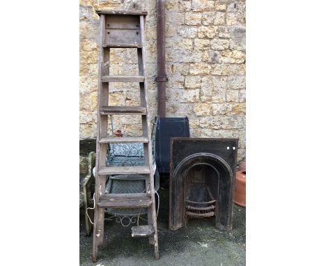 A cast iron fire surround and back plate, 61x92cm, together with a vintage stepladder (af) 