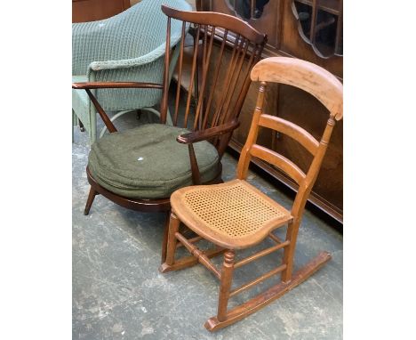 A low Ercol stickback open armchair; together with a caned rocking chair 