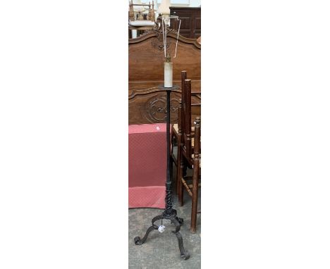 A wrought iron floor standing candlestick, on tripod base, converted for electrical use 
