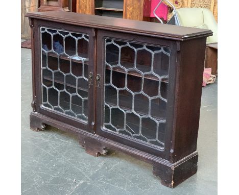 An early 20th century lead glazed bookcase, moulded top over two doors, on bracket feet, 164x38x109cmH 