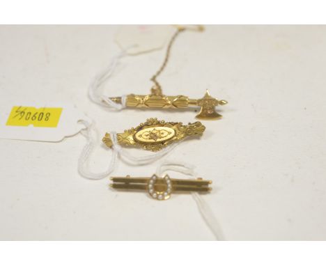 A 19th Century yellow metal axe pattern bar brooch, with engraved leaf decoration, 5cms wide; an early 20th Century yellow me