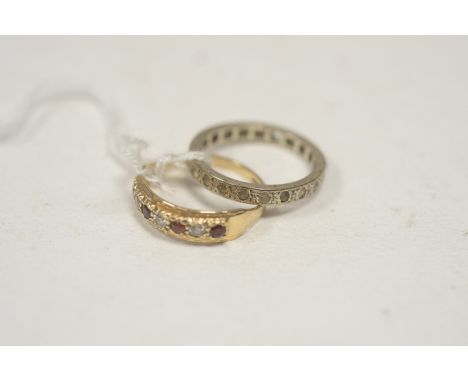 A garnet and white stone ring on 9ct. gold shank, ring size N; together with a white stone eternity ring in white metal mount