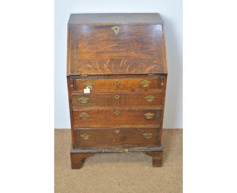 A Georgian oak bureau of narrow proportions, the rectangular fall-flap enclosing a fitted interior, four long drawers below, 