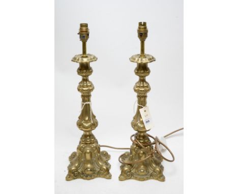 A pair of modern brass table lamps of rococo design, each 49cms high to top of light fitting.