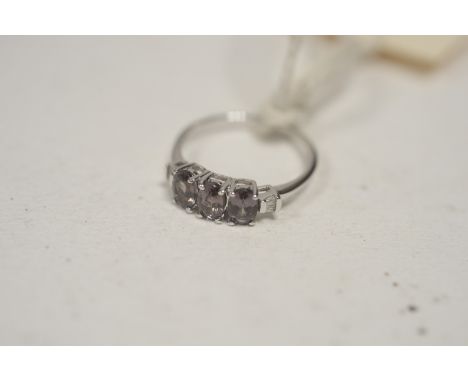 A colour change garnet and diamond ring, the three oval facet-cut garnets flanked by tapering baguette-cut diamond shoulders,