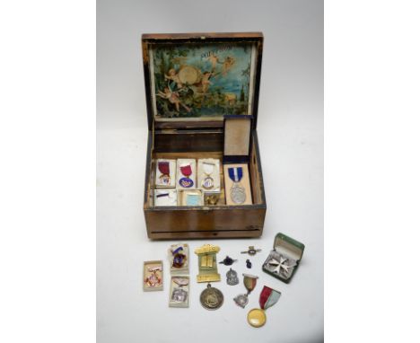 A selection of Masonic medals; an Air Raid Patrol silver lapel; medallions; badges; and other items in a polyphon box.