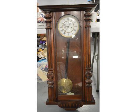 An early 20th Century walnut cased Vienna wall clock, the white enamel roman dial with subsidiary seconds aperture, 95cms hig