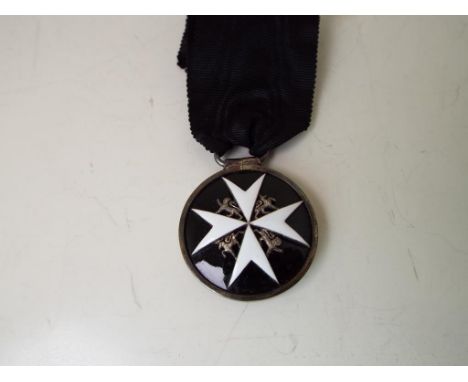 Order of St John Medal and ribbon - a circular silver breast badge with black and white enamel decoration and loop for ribbon