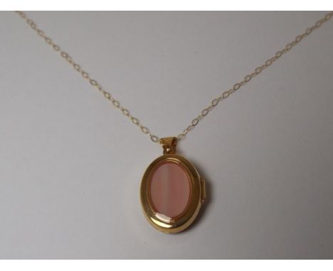 A lady's 9 carat gold mother-of-pearl oval locket and fine chain, approx. 2.8 gm, cased, unused surplus retail stock - Est £
