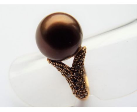 A lady's yellow metal ring stamped 750 set with a pearl to the centre with 0.50 carat of champagne diamonds to the shoulders,