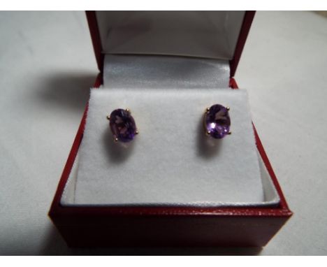 A pair of 9 carat gold amethyst stud earrings, 5 mm x 7 mm amethysts, boxed