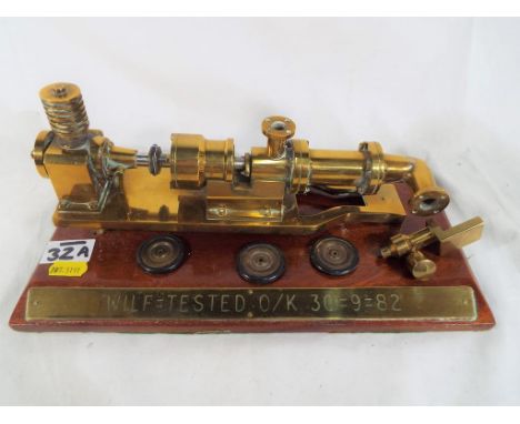 A brass engineering retirement gift on a mahogany plinth inscribed "Wilf tested O/K 30-9-82"