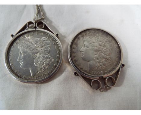 Two silver American one dollar coins with silver mount, one marked 1886 and the other with silver mount and silver chain mark