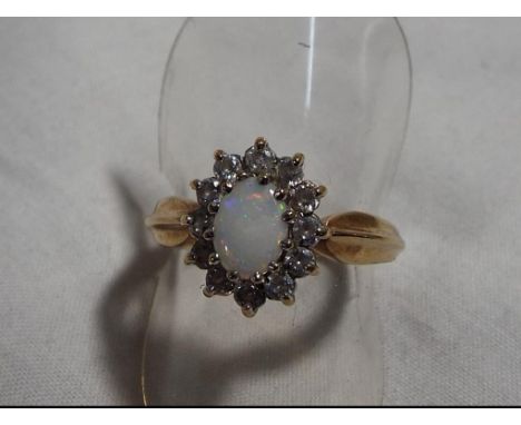 A lady's hallmarked 9 carat gold opal and cz cluster ring, approximate weight 3.4 grams, size O and a half, boxed