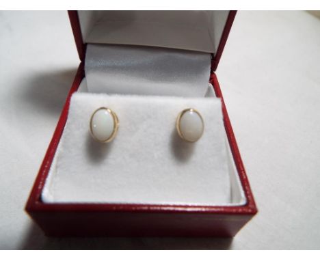 A pair of 9 carat gold and opal stud earrings, opals measure 5 mm x 7 mm, boxed