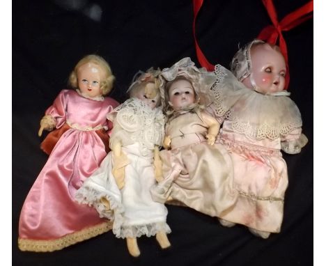 A collection of four vintage dolls, two with porcelain heads.