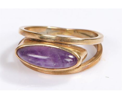 Yellow metal and amethyst set ring, with a naiveté cut amethyst, ring size K