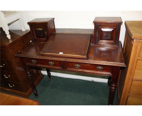 Edwardian writing desk, central writing slope flanked by two panelled cupboards, two frieze drawers on reeded turned legs, 11