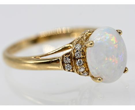 Ring mit Opal-Cabochon und 14 kleinen Achtkant-Diamanten, 20. Jh. 10 kt. Gelbgold. Gesamtgewicht ca. 3,2 g. Zentral gefasster