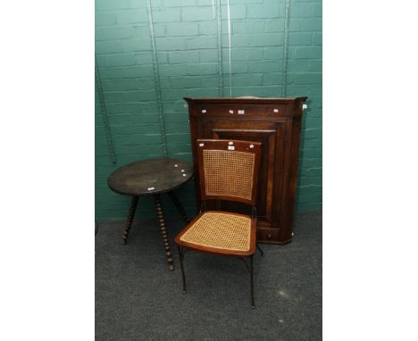 An 18th century oak single door hanging corner cupboard, with frieze drawers, 81cm wide, a wrought iron and split cane vintag