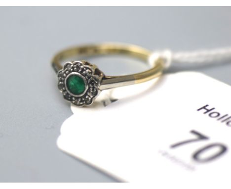 An emerald and diamond cluster ring, the circular emerald, millegrain mounted within a scalloped diamond border, to plain sha