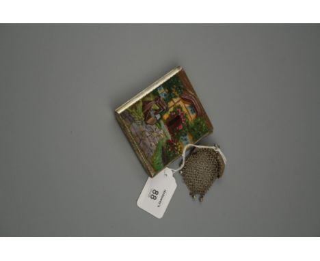 A silver and enamel cigarette case, the front with guilloché enamelled image of a thatched cottage with roses around the door