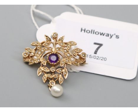 A gold amethyst and pearl pendant brooch, the Edwardian style open scrollwork brooch, with central circular cut amethyst and 