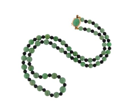 A jade and onyx bead necklace, the spherical beads graduate to 7.80mm. With a gold clasp set with a jade cabochon. 52cm long.