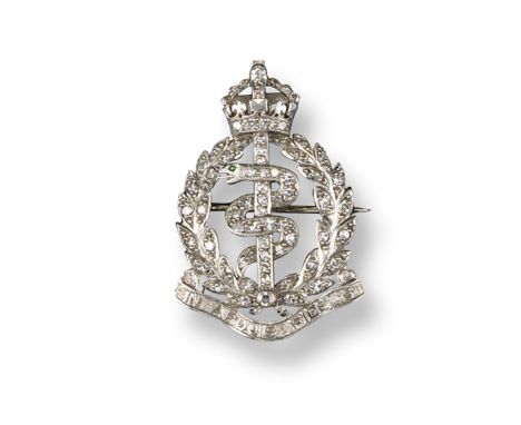 A military brooch for the Royal Army Medical Corps, set overall with circular-cut diamonds and with a demantoid garnet to the