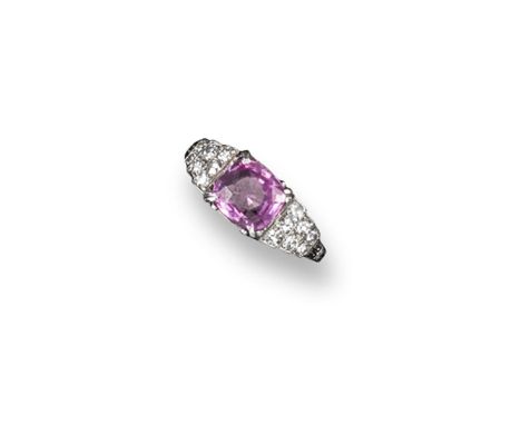 An early 20th century pink sapphire and diamond ring, the oval-shaped sapphire is set with seven small circular-cut diamonds 