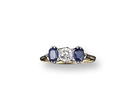 A sapphire and diamond three stone ring, the old circular-cut diamond is set with two oval-shaped sapphires in gold. Size T.